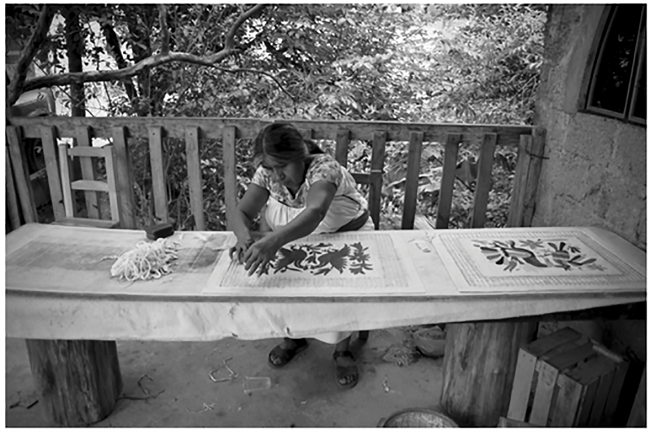 Artesana otomí de San Pablito, Pahuatlán, elaborando papel amate con incrustaciones de Tenangos 