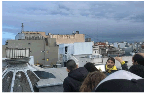 Gua de ET mostrando imgenes en una tablet durante el tour de Rooftops de Monserrat