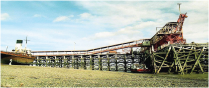 Fotografía actual tomada en el año 2015. El muelle de YCF fue
construido entre 1951 y 1956 para la carga en buques del mineral traído por
ferrocarril desde la mina de carbón ubicada en la localidad de Río Turbio a 300
km de esta ciudad. Este muelle no ha sufrido modificación por lo que conserva
hasta el día de hoy su fachada