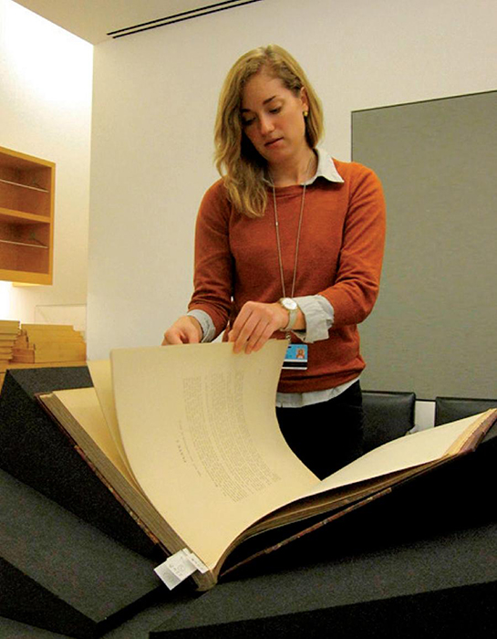 Julia McHugh en el Getty Research Institute con un volumen de “The necropolis of Ancon in Peru” de Wilhelm Reiss y Alphons Stübel.