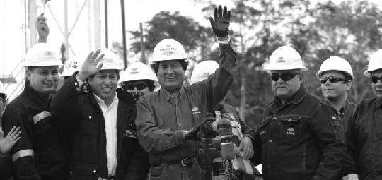 Liturgia del extractivismo petrolero: inauguración de un nuevo campo petrolero, donde el presidente Evo Morales (Bolivia) moja su mano en el crudo, la alza para recibir el aplauso de los asistentes, y luego procederá a bendecir con ella la cabeza de las autoridades que le rodean. Yapacaní,
junio 20157