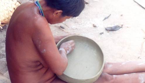 Maya carefully smoothing a kumé vessel used to serve food