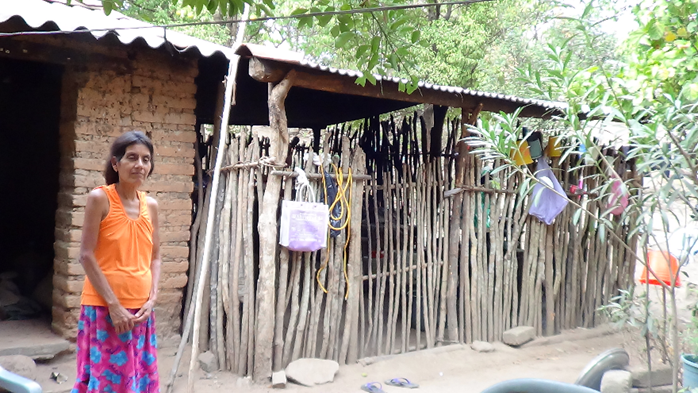Do&ntilde;a Josefa mostrando su tradicional casa de adobe con cocina de varas