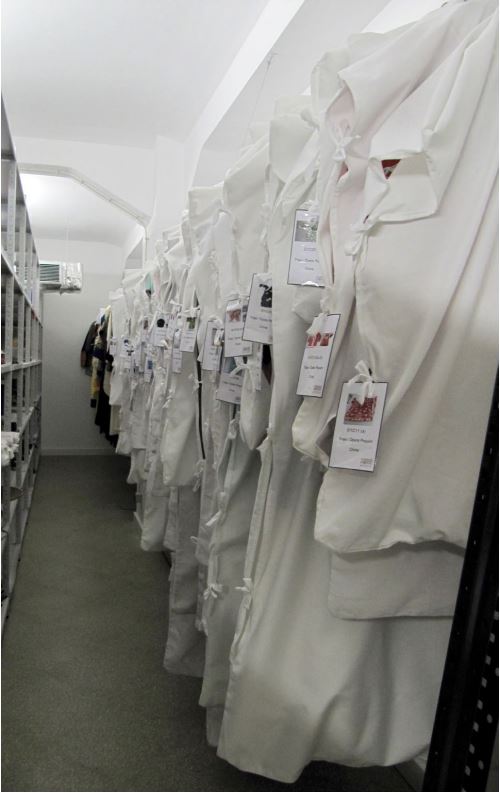 Trajes com capas protectoras armazenados em varão.