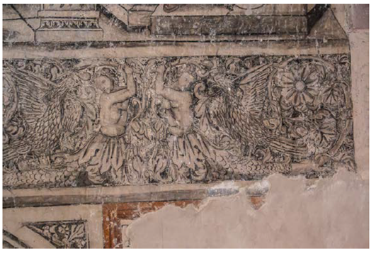 Escena de una de las cenefas del cubo de la escalera del convento de Actopan, Hidalgo. Es un águila muy parecida a la del ábside de Ixmiquilpan, pero aquí carece de atributos indígenas. Pisa el cuerpo de reptil o pez de un personaje grutesco que levanta de forma amenazante un garrote tronchado con el que parece atacar al águila.