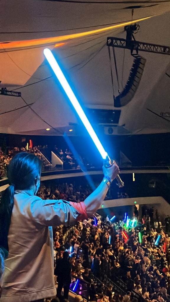 Seguidor empu&ntilde;ando su sable de luz cuando Dave Filoni aparece en el escenario durante la Star Wars Celebration, Anaheim, California, mayo de 2022