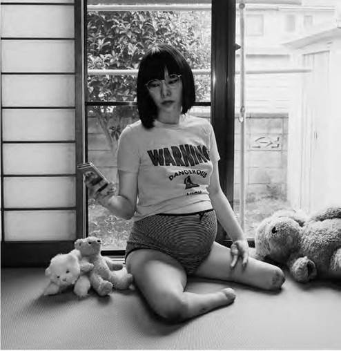 • Performance de Mari Katayama, artista japonesa con discapacidad, tomándose una selfie, sentada en el piso rodeada de muñecos, 2018 | Tomada de: Medusabionicris