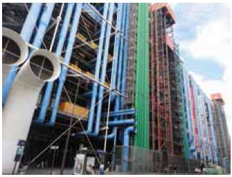 Centre Pompidou. Fachada posterior, sobre la rue du Renard / rue Beaubourg. Fachada posterior del Centre Pompidou, sobre la rue du Renard/rue Beaubourg, en la cual sobresalen los elementos en cuatro colores según su función: azul para instalaciones de climatización; amarillo para instalaciones eléctricas; verde para instalaciones hidráulicas; y rojo para elementos de circulación (escaleras mecánicas y ascensores).-