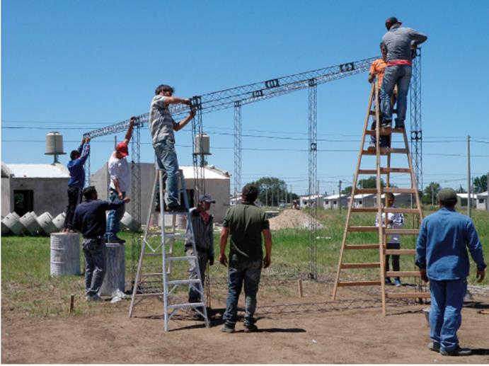 Cooperativistas junto a participantes del CEVE y representantes del IMV realizando el ensamblado de la estructura met&aacute;lica del prototipo en la ciudad de R&iacute;o Cuarto