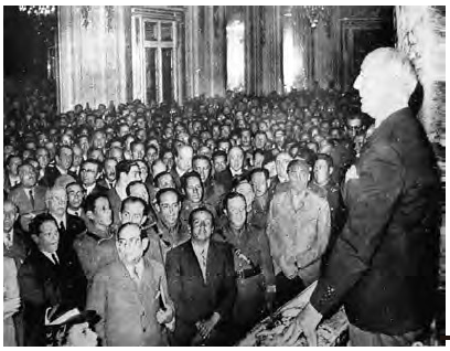 El presidente Prado frente a una marcha patriótica en la cual destacan los uniformes