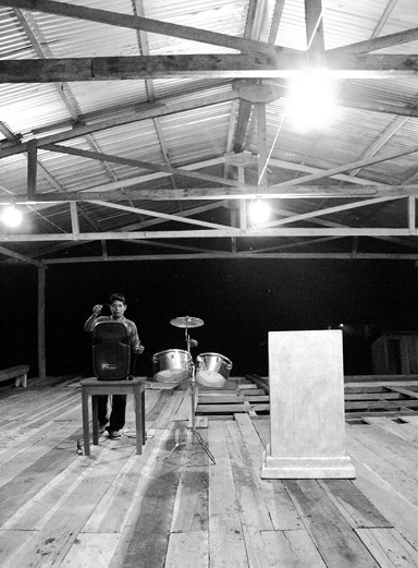 Un poblador urarina prepara el parlante, alimentado por un generador de luz, antes de empezar el culto en la comunidad nativa de Nueva Unión (departamento de Loreto)