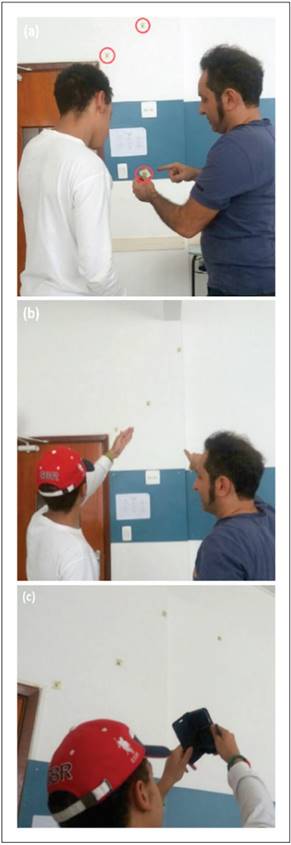 A sala de aula como observat&oacute;rio: (a) o professor pergunta ao estudante onde colocaria o post-it com a apar&ecirc;ncia da Lua; (b) o estudante explica o seu racioc&iacute;nio e fixa o post-it, e, em seguida (c) confirma a posi&ccedil;&atilde;o da Lua com o celular. Os pap&eacute;is com a data de observa&ccedil;&atilde;o e o desenho da apar&ecirc;ncia da Lua fixos na parede e na m&atilde;o do professor est&atilde;o destacados na figura (a).