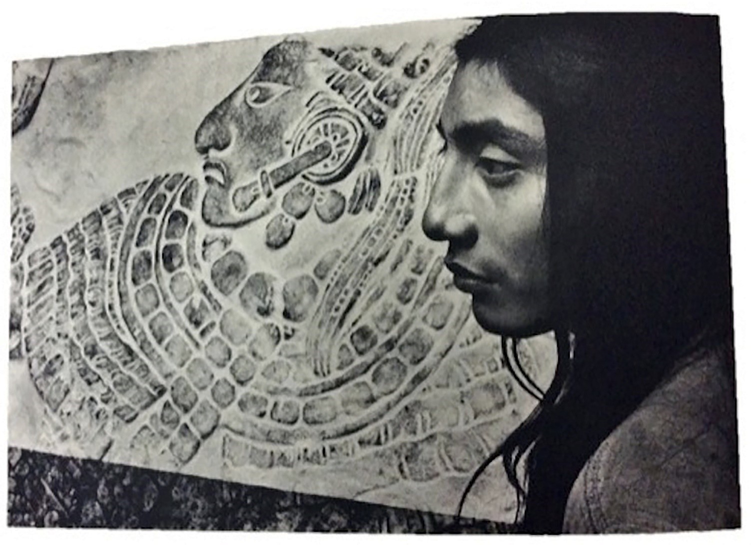 Foto de un joven con la figura del antiguo maya de fondo