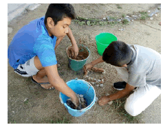 Dos niños realizan corrales de ganado en miniatura en un pedido católico.