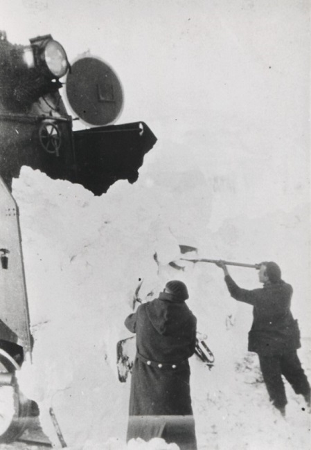 Obreros despejando la nieve del testero de una locomotora “Mastodonte” en la línea Gijón-León, durante una nevada en la década de 1950