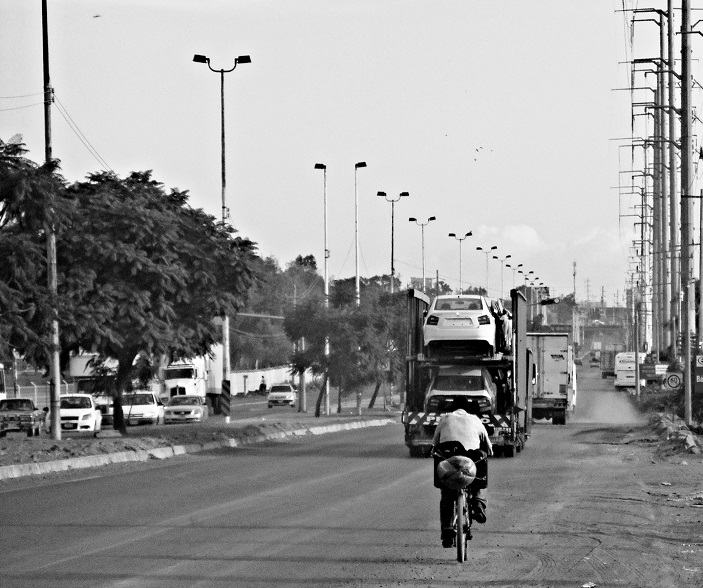 Ciclista en medio del tráfico del Corredor Industrial de El Salto.