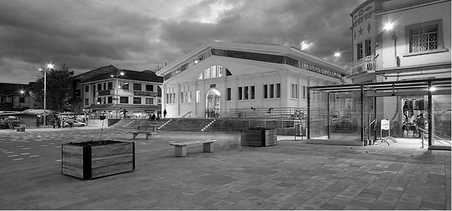 - Mercado 9 de Octubre. En primer plano se observa la plaza, el edificio restaurado aparece sobre los grader&iacute;os. Fuente: Albornoz (2012).