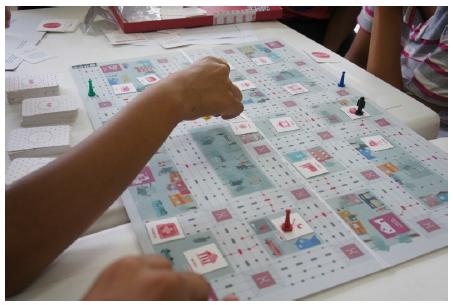 Tabuleiro do Jogo, fichas representando os edifícios e equipamentos da cidade, pilhas de mobilicartas referentes a cada modal.