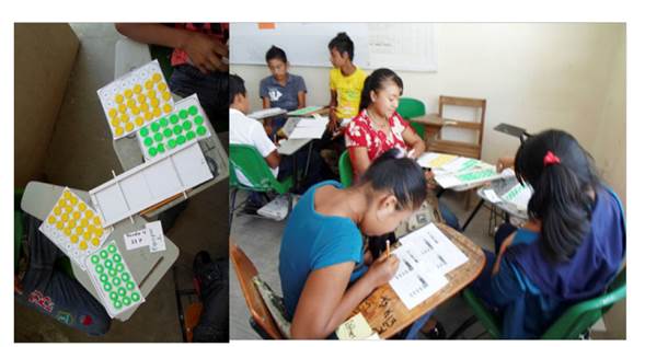 Jóvenes de telesecundaria durante el juego de El carga palito. Tableros y fichas en su versión casera, preliminar. Ejido Los Ángeles, Villaflores. Julio 2014. 