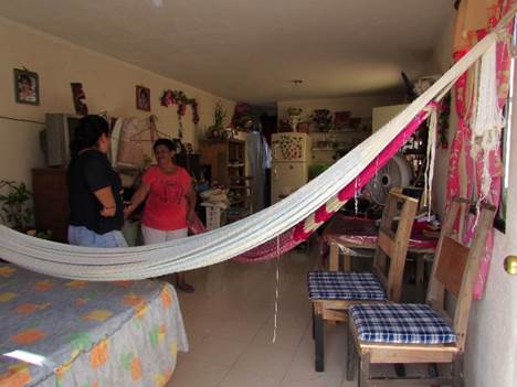 Vivienda m&iacute;nima amueblada. Se observa una cama y dos sillas de comedor en la sala con presencia de hamacas.