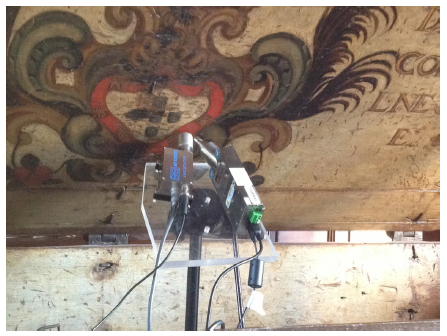 Fotografia no momento de medi&ccedil;&atilde;o do ponto P4 da arca-cofre, incidindo na tinta vermelha do bras&atilde;o da arca. 