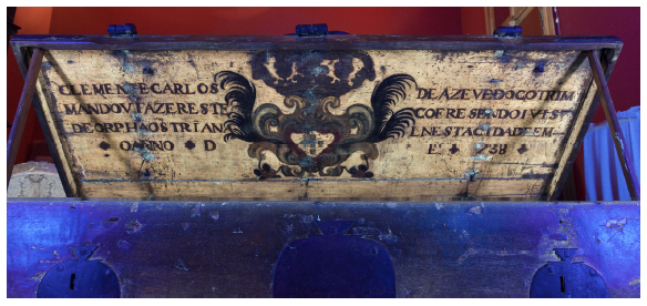 Fotografia com fluoresc&ecirc;ncia de luz UV na arca RG 3242, onde se evidenciam sinais de restauro, como as tr&ecirc;s linhas verticais na parte interna do tampo. A ED-XRF revelou outros tipos de tintas usadas no restauro. Acervo do Museu Paulista.