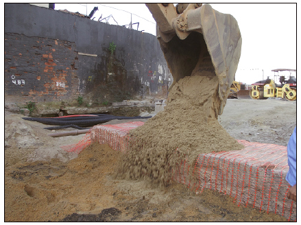 O p&iacute;er principal, sinalizado por tela tapume e protegido por uma camada de areia, e a rua novamente asfaltada. Foto: Andrea Jundi.