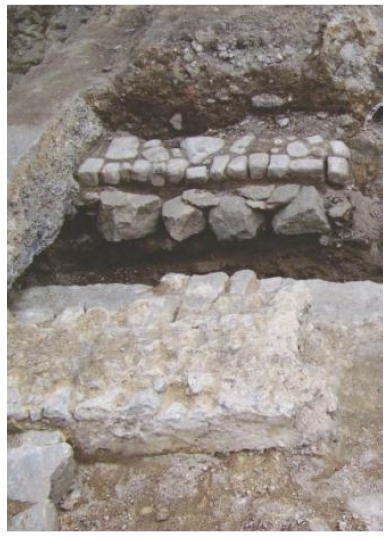 Ao fundo, o cal&ccedil;amento inferior de pedras retangulares alongadas, e, por cima dele, o cal&ccedil;amento misto de paralelos e pedras arredondadas irregulares na extremidade da Rua Argemiro Bulc&atilde;o, pr&oacute;xima &agrave; Rua Sacadura Cabral. A foto mostra claramente como a amplia&ccedil;&atilde;o do trapiche foi feita sobre o leito do Beco da Pedra do Sal, chegando mesmo a aproveitar alguns dos seus paralelos no cal&ccedil;amento interno do edif&iacute;cio. Foto: Andrea Jundi.