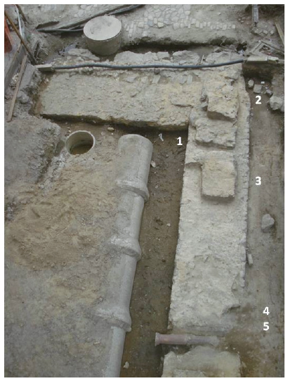 Alicerces na esquina do antigo Beco da Pedra do Sal (atual Rua Argemiro Bulc&atilde;o) e da Rua da Sa&uacute;de (atual Rua Sacadura Cabral) e os achados associados: (1) concentra&ccedil;&atilde;o de seixos; (2) miniaturas de potes; (3) moeda datada de 1868; (4) e (5) concentra&ccedil;&atilde;o de seixos. Foto: Andrea Jundi.