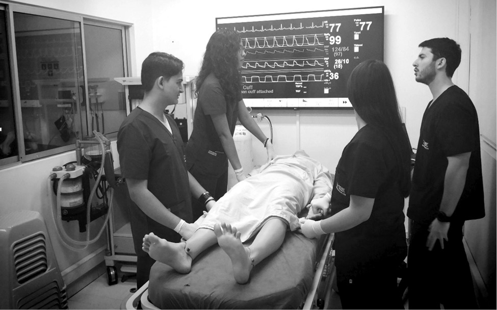  Grupo de estudiantes en el Laboratorio de Simulación con una réplica de un escenario clínico, Universidad Pontificia Bolivariana, Medellín
