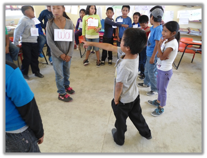 Alumnos participando entusiasmadamente en un juego de lectura de reconocimiento
de números tu’un savi