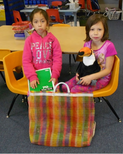 Karen and Luz posing with the bag containing their family journal and the stuffed animal (a toucan named Tom�s)