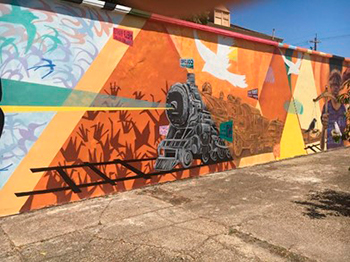 Paineis do mural “These Are Times” de Scott Ayo (2018) no lugar onde Homer Plessy foi reitrado do trem em New Orleans, vinculando seu ato de resistenciâ à luta para derrubar a segregação escolar.