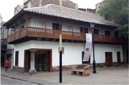Casa del Corregidor, Santiago de Chile. El trabajo lignario del balc&oacute;n corrido en la segunda planta recuerda las labores mud&eacute;jares extendidas por todas las colonias espa&ntilde;olas, aunque en el caso que nos ocupa se hayan fusionado con las formas b&aacute;varas que triunfaron en Chile durante el siglo XVIII y que tantos ejemplos ha dejado a lo largo del territorio.