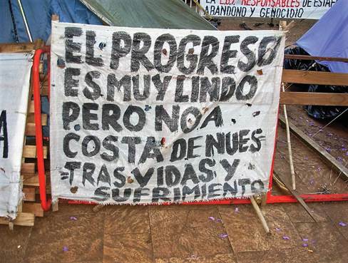"El progreso es muy lindo, pero no a costa de nuestras vidas y sufrimiento", manifestaci&oacute;n de los relocalizados del barrio El Brete en la Plaza San Mart&iacute; de Posadas, a&ntilde;o 2007.