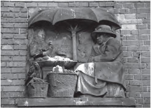 Relieve escultórico en uno de los muros del mercado de Breslau y un día de mercado en la plaza de Girardot. Describen ambas la tradición del intercambio en medio de la ciudad, bajo una cubierta protectora. Fuente: Fotografía de Eduardo Samper Martínez.