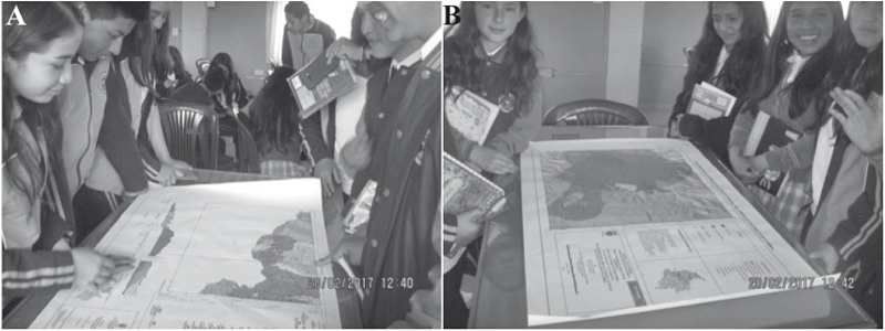 Estudiantes de la IE Jos&eacute; Antonio Llorente participando en actividades durante una de las conferencias. A. Observan el mapa geol&oacute;gico 447 Ipiales (Vel&aacute;squez y Parra, 2002). B. Estudio del mapa de amenaza del CVC (INGEOMINAS, 2000).