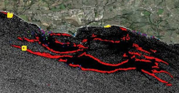 Detalle de diferencia de detecci&oacute;n de hidrocarburos con imagen Sentinel 1 del primero de agosto de 2018 entre polarizaci&oacute;n VV (rojo) y VH (amarillo). N&oacute;tense los cuadrados amarillos correspondientes a falsos positivos alrededor de plataformas petroleras.
