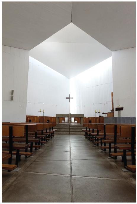 Arestas iluminadas no encontro entre parede e teto piso com desenho em flecha.