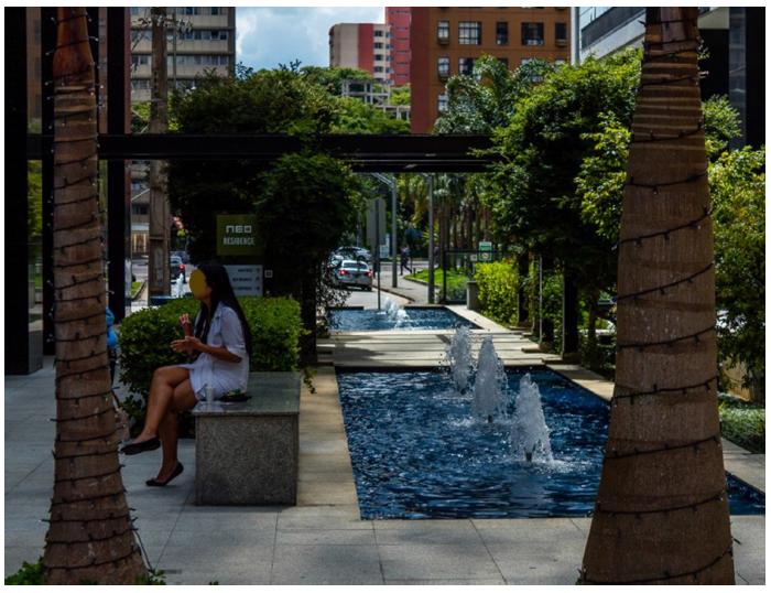 Vista interna do boulevard Neo Superquadra, com a disposição do calçamento, bancos, vegetação e espelhos d’água.