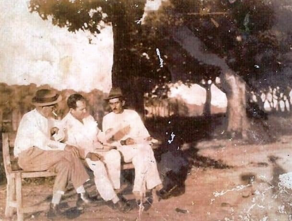 Fotografia de Aluízio Ferreira (ao centro), ladeado por Américo Casara (à direita) e um trabalhador à esquerda no seringal Laranjeira, provavelmente dos anos de 1930.
