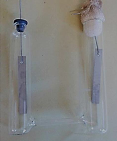 Celda tipo H fabricada en el Instituto Nacional de Investigaciones Nucleares. Se puede ver el tubo de vidrio que une a los tubos de ensaye. Como electrodos se utilizó acero inoxidable