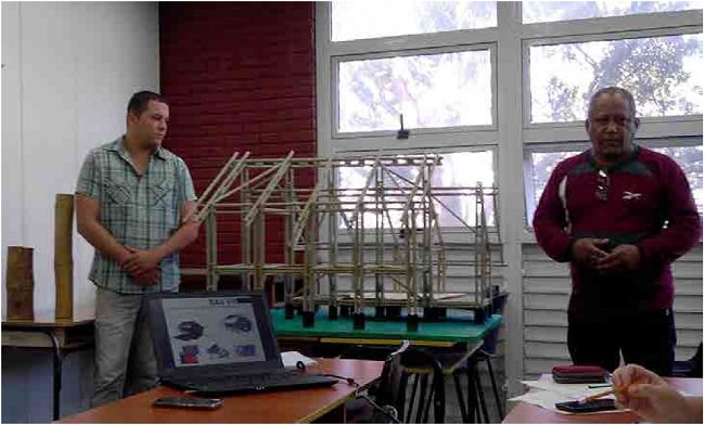 Sesi&oacute;n de trabajo en el que se presenta el modelo de caba&ntilde;a de bamb&uacute;. Izquierda: estudiante Jorge P. Fonseca, derecha: ingeniero Carlos Mart&iacute;nez. Fuente: autores.