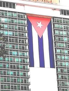 Hotel Habana Libre, con la bandera cubana gigante adosada sobre su fachada para hacerla visible a distancia y enfatizar el s&iacute;mbolo. 