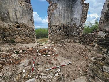 �rea interna de la habitaci�n Sur de la Estructura 1 donde se observa parte del piso original de baldosas de cer�mica (24 x 24 cm) y un pozo de saqueo.