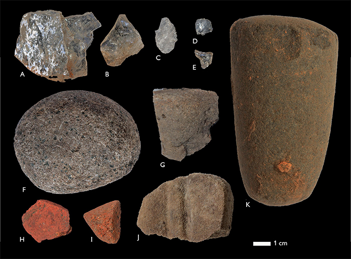 Lithic materials from Cerro Gavil&aacute;n 2: A, B, D, E) crystalline quartz flakes, levels 4, 5, surface, 3, respectively; C) quartz flake, level 3; F) nutting stone, surface; G) fragment with signs of abrasion on one surface, level 9; H, I) goethite fragments with signs of abrasion,levels 2 and 5 respectively; J) stone with u-shaped grooves, surface; K) conical grinding stone, found in back dirt of looter&rsquo;s pit adjacent to excavation pit 1. Photos by Franz Scaramelli.