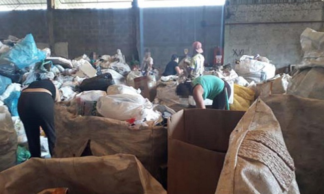– Catadores trabalhando e mobilizando o corpo em meio aos bags com materiais