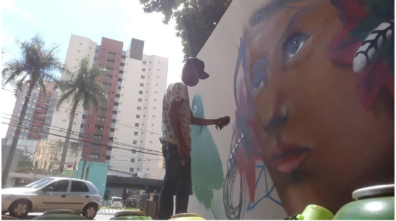 Soverino Mygso Borges, artista Kaingang, produzindo graffiti nos muros do Col&eacute;gio Estadual Vicente Rijo. Soverino integra o Grupo Nēn Ga, ao lado de jovens artistas que residem na Terra Ind&iacute;gena Apucaraninha, e participa do movimento de Arte Urbana na cidade de Londrina, Paran&aacute;. Fotografia do artista. Facebook, p&aacute;gina de Soverino Mygso Borges, (17 de janeiro de 2020).