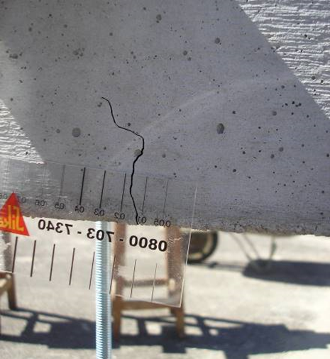 Measurement of the crack opening in the center of the prismatic specimen with a crack meter.