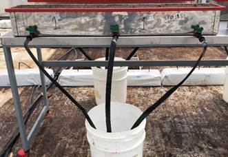 Recipiente met&aacute;lico con sus respectivos drenajes (a) que contiene una tabla de fibra de coco saturada de un volumen aproximado de 18,2 L (b). 